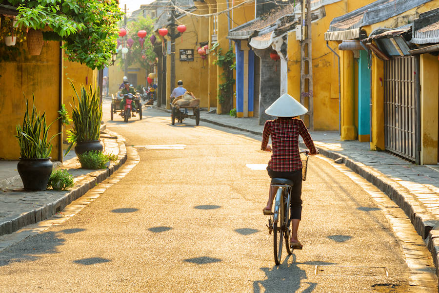 900 woman in traditional hat bicycling along Hoi AnAdobeStock 297983025